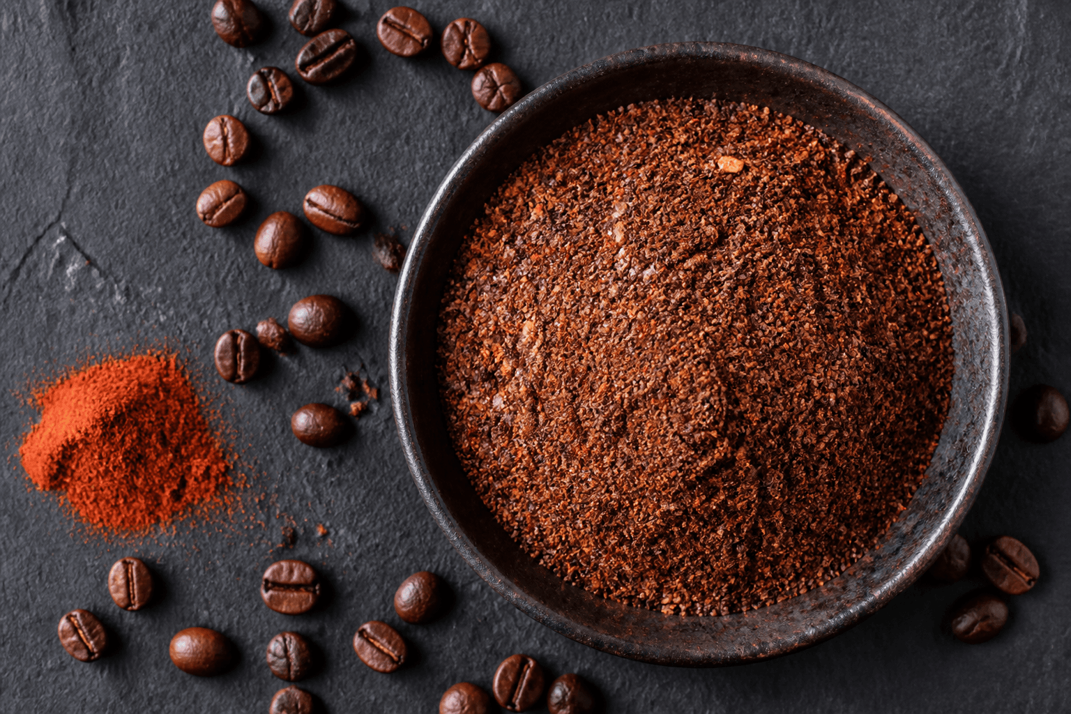 Skål med mørk kaffe-rub, kaffepulver og chiliflager