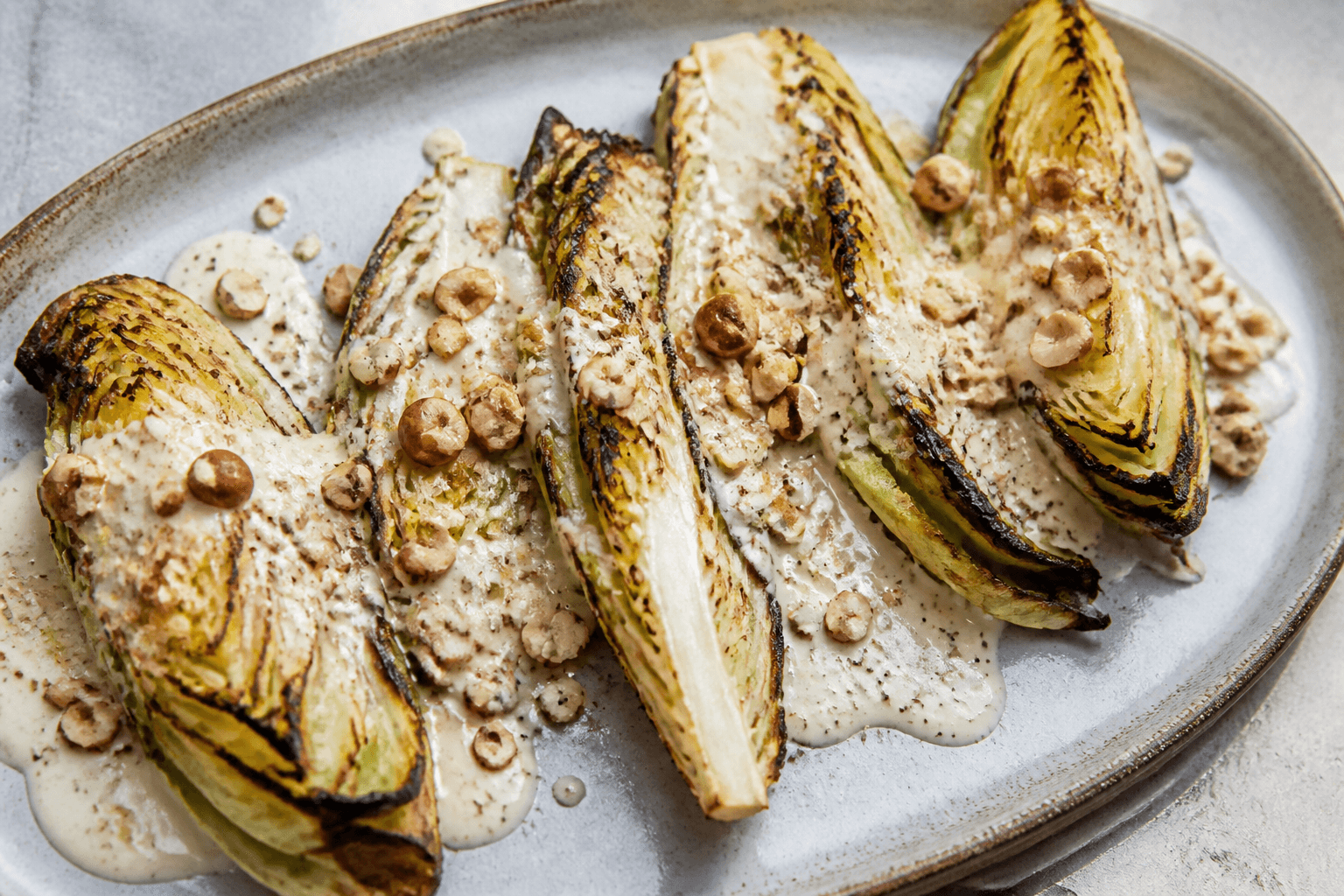 Grillede spidskålsbåde med parmesancreme og hasselnødder